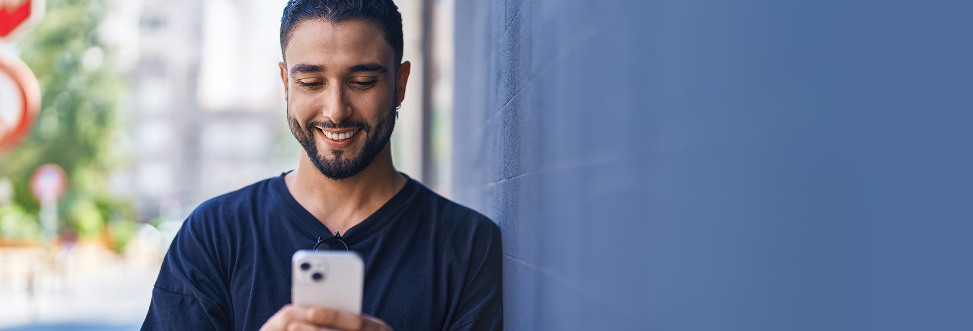 young man smiling at smartphone